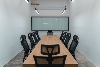 High angle view of empty chairs and table against wall