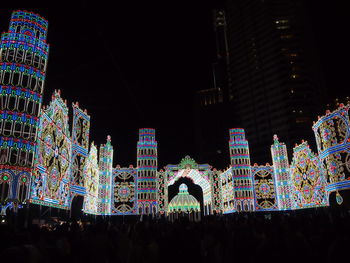 Illuminated city against sky at night