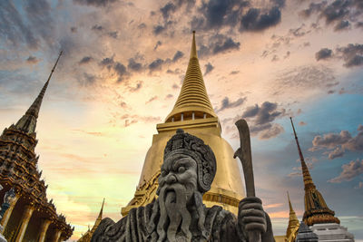 Low angle view of statue of building against cloudy sky