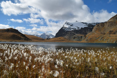 Scenic view of lake by mountains against sky