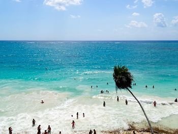 People swimming in sea against sky