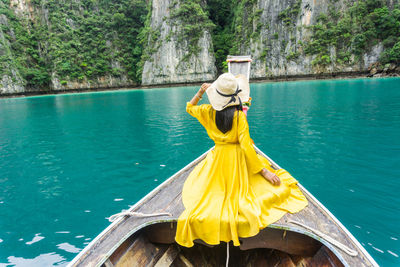 Rear view of woman with umbrella on boat