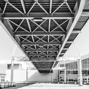 Low angle view of bridge amidst buildings against sky