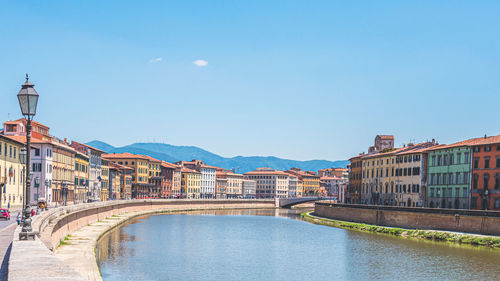 Arch bridge over river against buildings in city