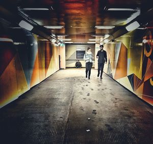 People in illuminated underground walkway