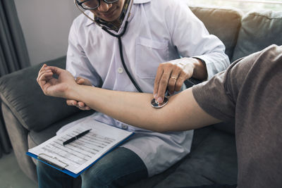 Midsection of doctor examining man