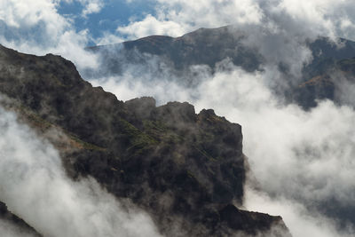 Smoke emitting from mountain against sky