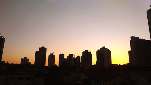 Silhouette buildings against sky during sunset