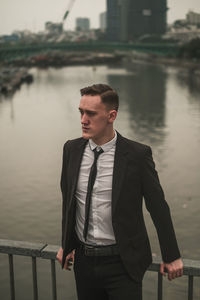 Young man standing against lake