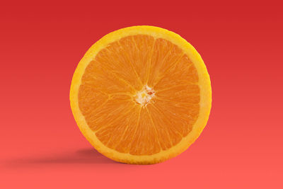 Close-up of orange slice against red background