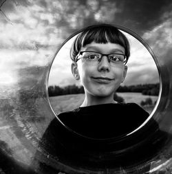 Portrait of a smiling boy against sky, framed in a transparent swimming ring