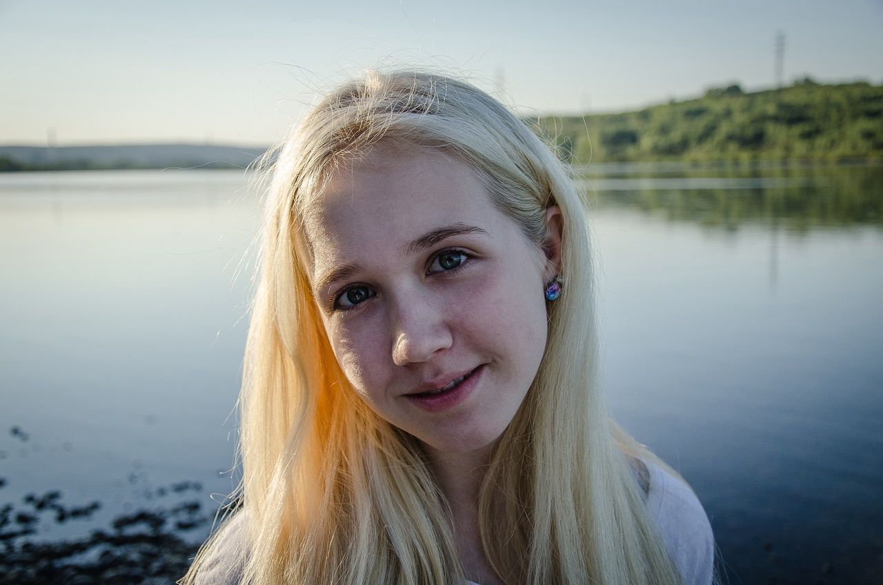 headshot, portrait, looking at camera, water, young adult, person, close-up, focus on foreground, front view, head and shoulders, smiling, lifestyles, day, outdoors, sea, sunglasses, human face