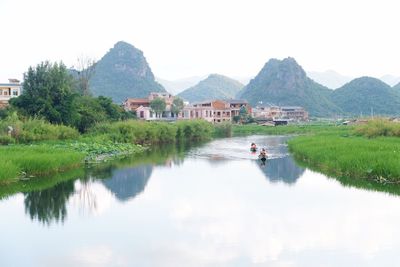 Scenic view of lake and buildings against sky