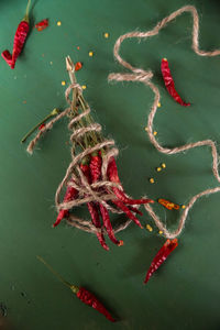 High angle view of red chili peppers tied with string on table