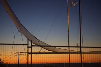 Silhouette of suspension bridge against sky during sunset