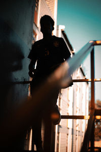 Low angle view of man standing against railing