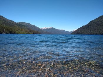 Scenic view of lake against clear blue sky