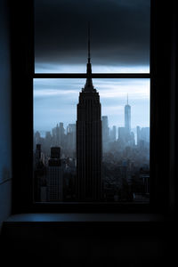 Buildings in city seen through glass window