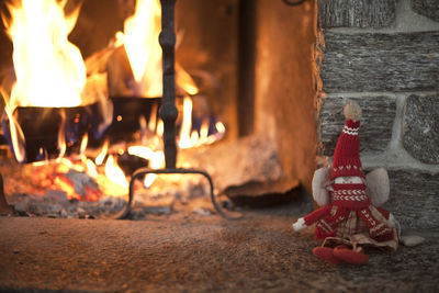 Puppet against wall with fire burning in background