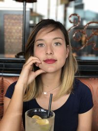 Portrait of young woman drinking glass