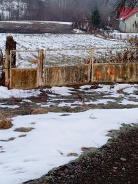 Snow covered land by lake