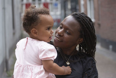 A black mother tries to calm her upset baby daughter