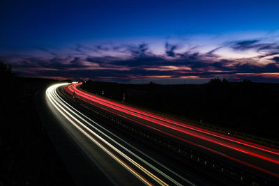 High angle view of light trails on highway against sky during sunset