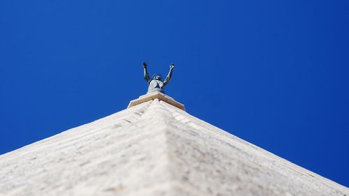 Low angle view of statue against blue sky