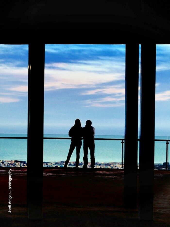 silhouette, sea, sky, horizon over water, water, men, lifestyles, sunset, indoors, standing, person, leisure activity, cloud - sky, full length, rear view, railing, nature, togetherness