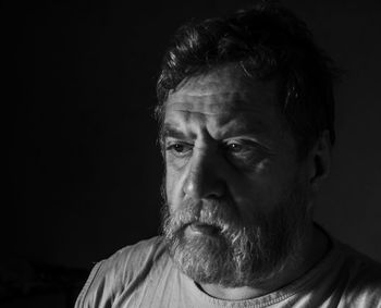 Close-up of portrait of man against black background