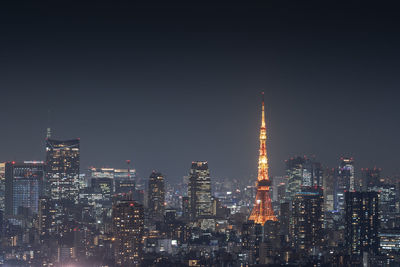 Illuminated buildings in city against sky