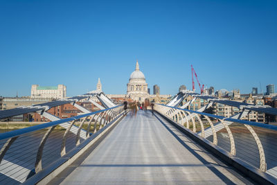 View of footbridge in city against clear sky