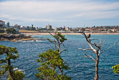 Scenic view of sea by city against sky