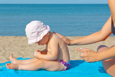 Midsection of woman relaxing on beach