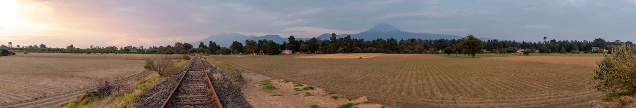 Panoramic view of agricultural field against sky