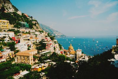 High angle view of buildings by sea against sky