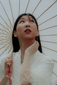 Portrait of young woman holding umbrella