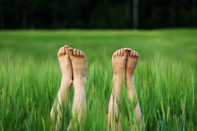 Low section of person relaxing on field