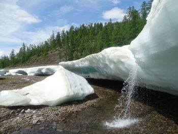 Scenic view of waterfall against sky