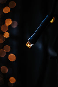 Low section of woman holding illuminated string lights