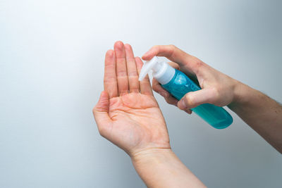 Close-up of hand holding hands over white background