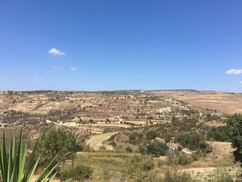 Scenic view of landscape against blue sky