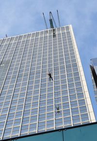 Low angle view of flying by building against sky