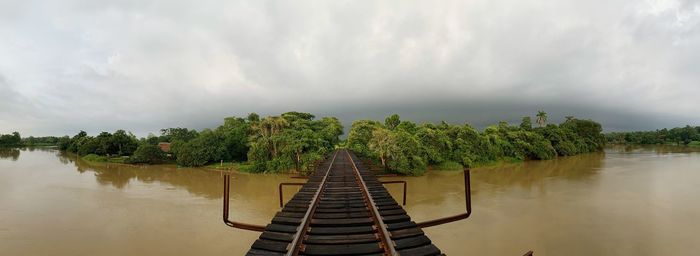 Panoramic view of trees by lake against sky