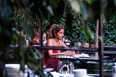 Portrait of young woman sitting on chair at table