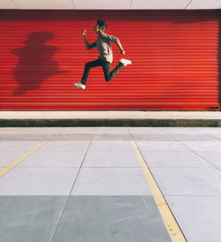 Low angle view of man jumping on tiled floor