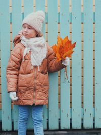 Full length of woman standing in snow during autumn