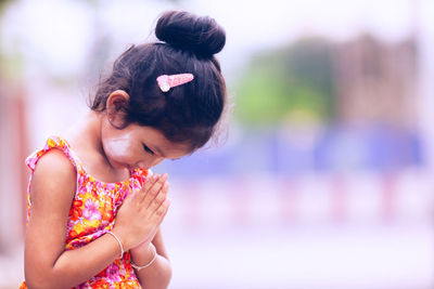 Cute girl praying outdoors