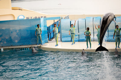 People swimming in pool by sea