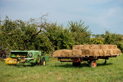 Lounge chairs in field against sky